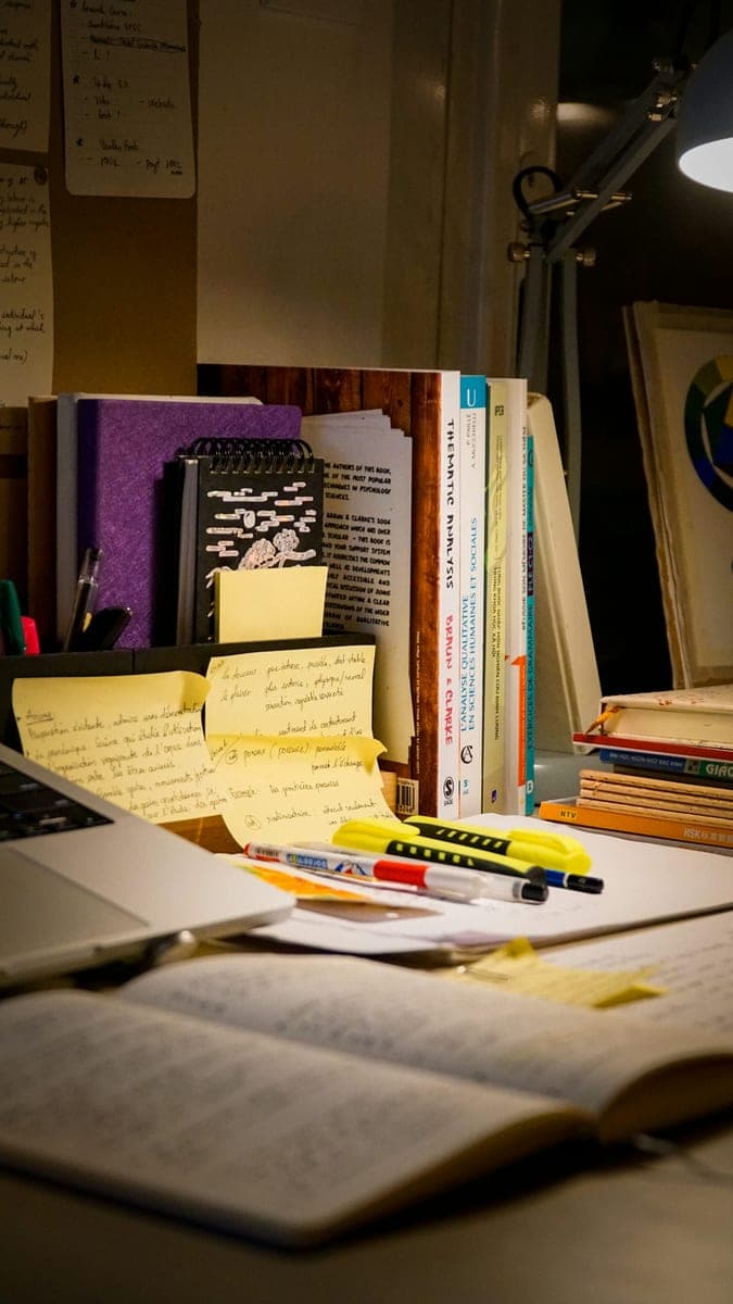 Учебники, открытая книга и рукописные записи на рабочем столе