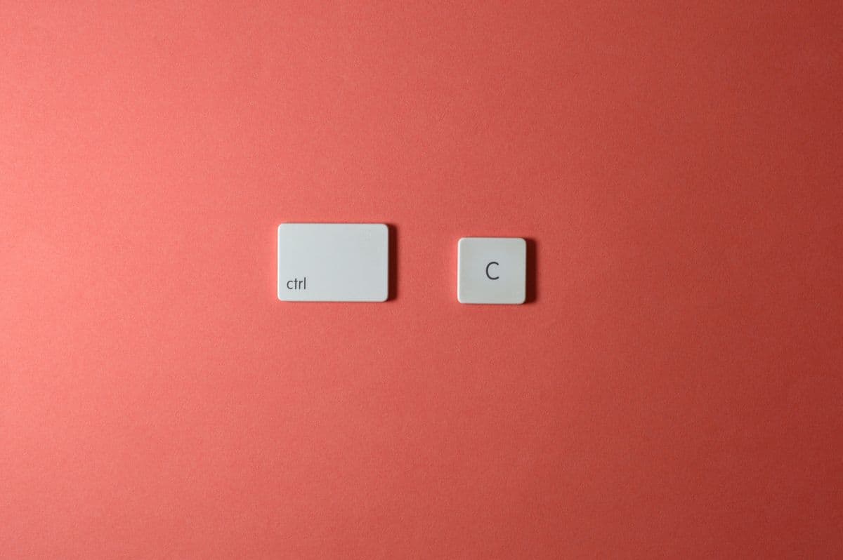 Две белые клавиши ctrl и C на коралловом фоне — сочетание для копирования