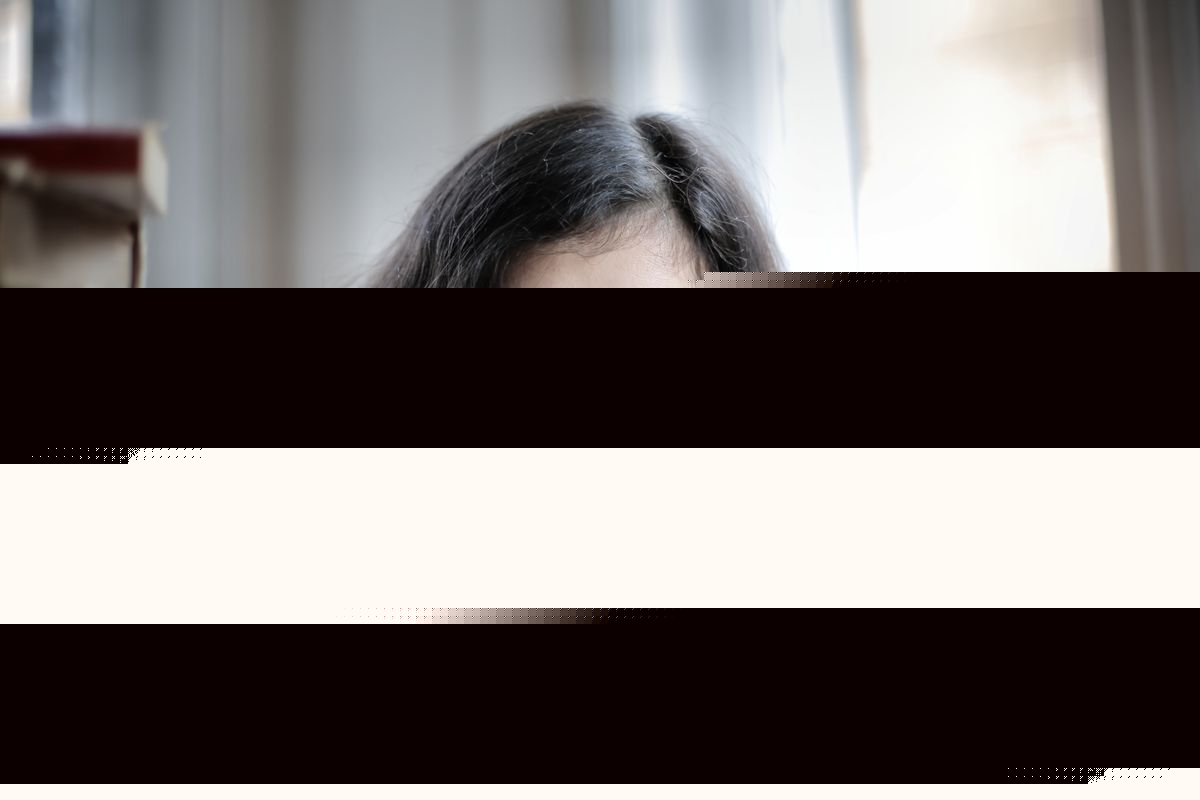 Уставший студент за столом с учебниками и ноутбуком вечером